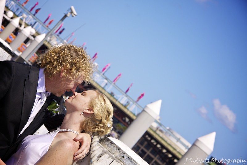 Bride and groom kissing at the wharf - wedding photography